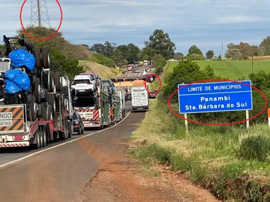 | Imagem do acidente divulgada pelo Portal Assinck. É possível ver, além da placa de limite do município em primeiro plano, uma placa de ultrapassagem proibida ao fundo, na margem direita da rodovia, bem próxima à carreta tombada, e uma torre no lado esquerdo da rodovia. / Projeto Comprova