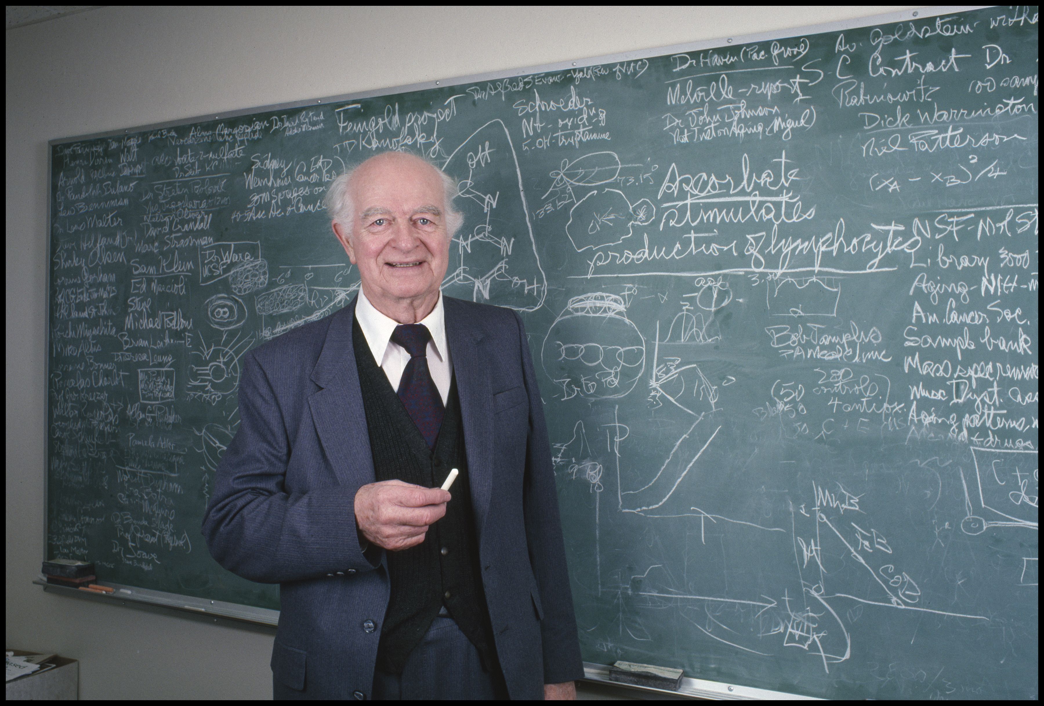 Retrato do cientista americano Linus Pauling, duas vezes ganhador do Prêmio Nobel, enquanto posa em frente a uma lousa no Instituto Linus Pauling, em Menlo Park, na Califórnia, em meados de janeiro de 1983. / Janet Fries/Getty Imagens