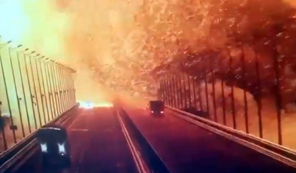 CRIMEIA - 08 DE OUTUBRO: Uma captura de tela de uma filmagem de vigilância mostra chamas e fumaça subindo após uma explosão na ponte Kerch no Estreito de Kerch, Crimeia, 8 de outubro de 2022. Uma ponte que liga a Crimeia à Rússia pegou fogo no sábado de manhã causando suspensão de tráfego, uma vez que todos os serviços ferroviários para a Crimeia foram temporariamente suspensos. A Ponte Kerch - um par de pontes paralelas, uma estrada e uma ferrovia - é uma importante rota de abastecimento para a Rússia, construída após a anexação da Crimeia em 2014.