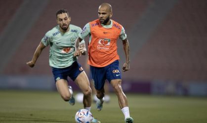 Daniel Alves corre sob os olhares de Alex Telles em treino da Seleção Brasileira no Estádio Grand Hamad, em Doha, Catar
