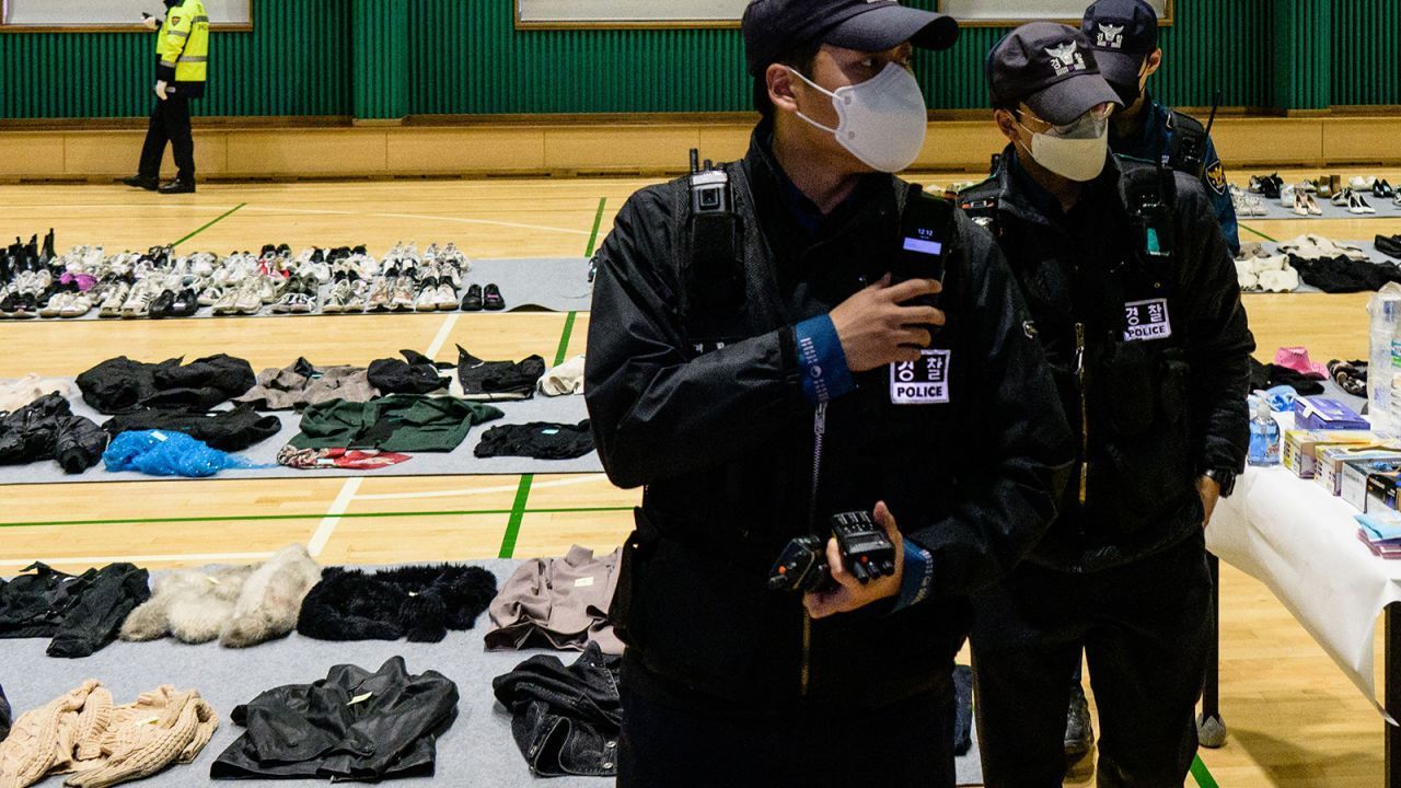 A polícia anda entre pertences pessoais recuperados da cena de uma onda fatal de mortes no Halloween. Anthony Wallace/AFP/Getty Images