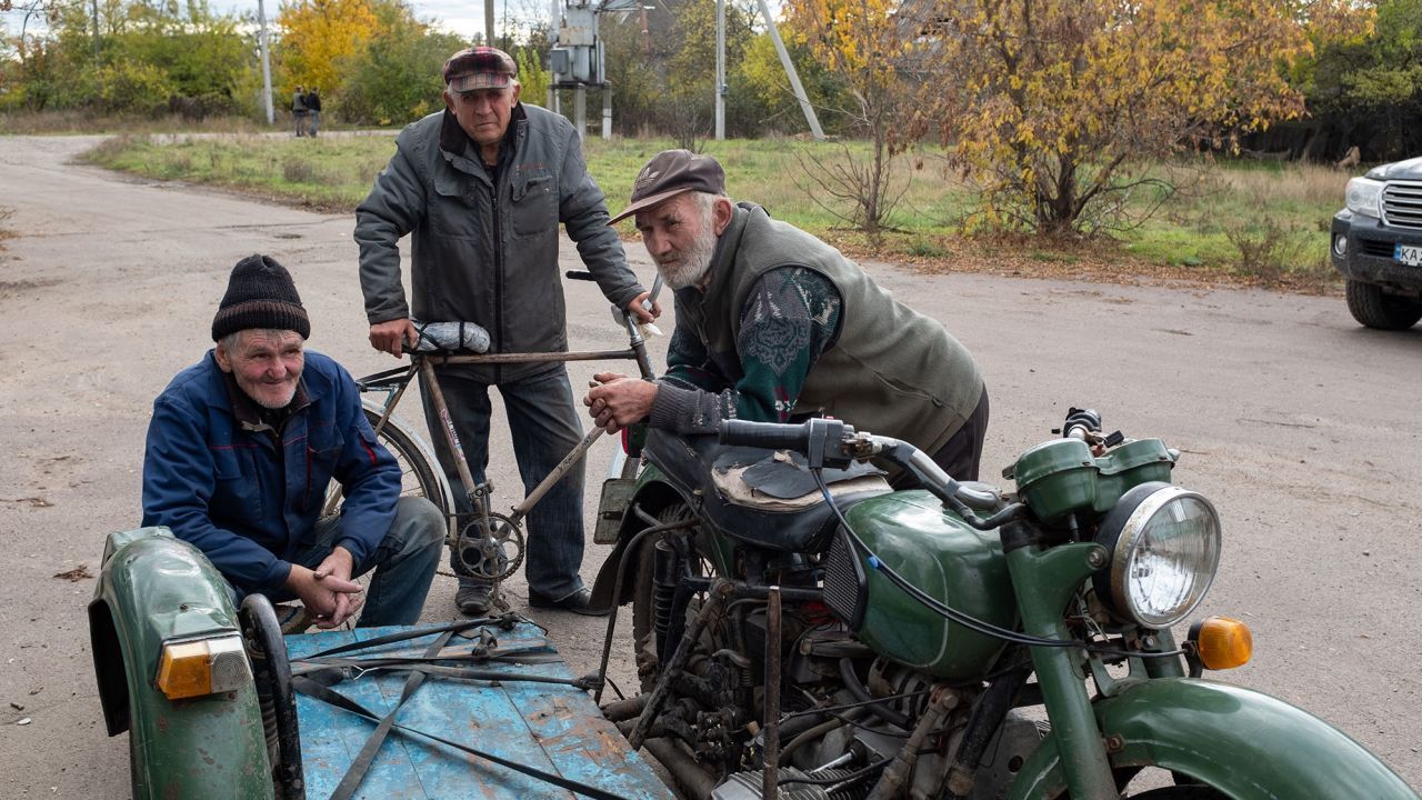 Aldeões são fotografados em uma cidade anteriormente ocupada pelos russos na região de Kherson, no sul da Ucrânia / Mick Krever/CNN