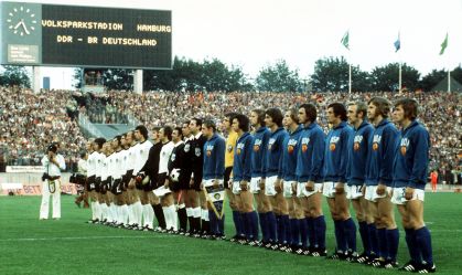 As seleções nacionais de futebol da Alemanha Oriental (de azul) e Ocidental (de branco) estão em fila para os hinos nacionais antes do início da partida na Copa do Mundo de 1974