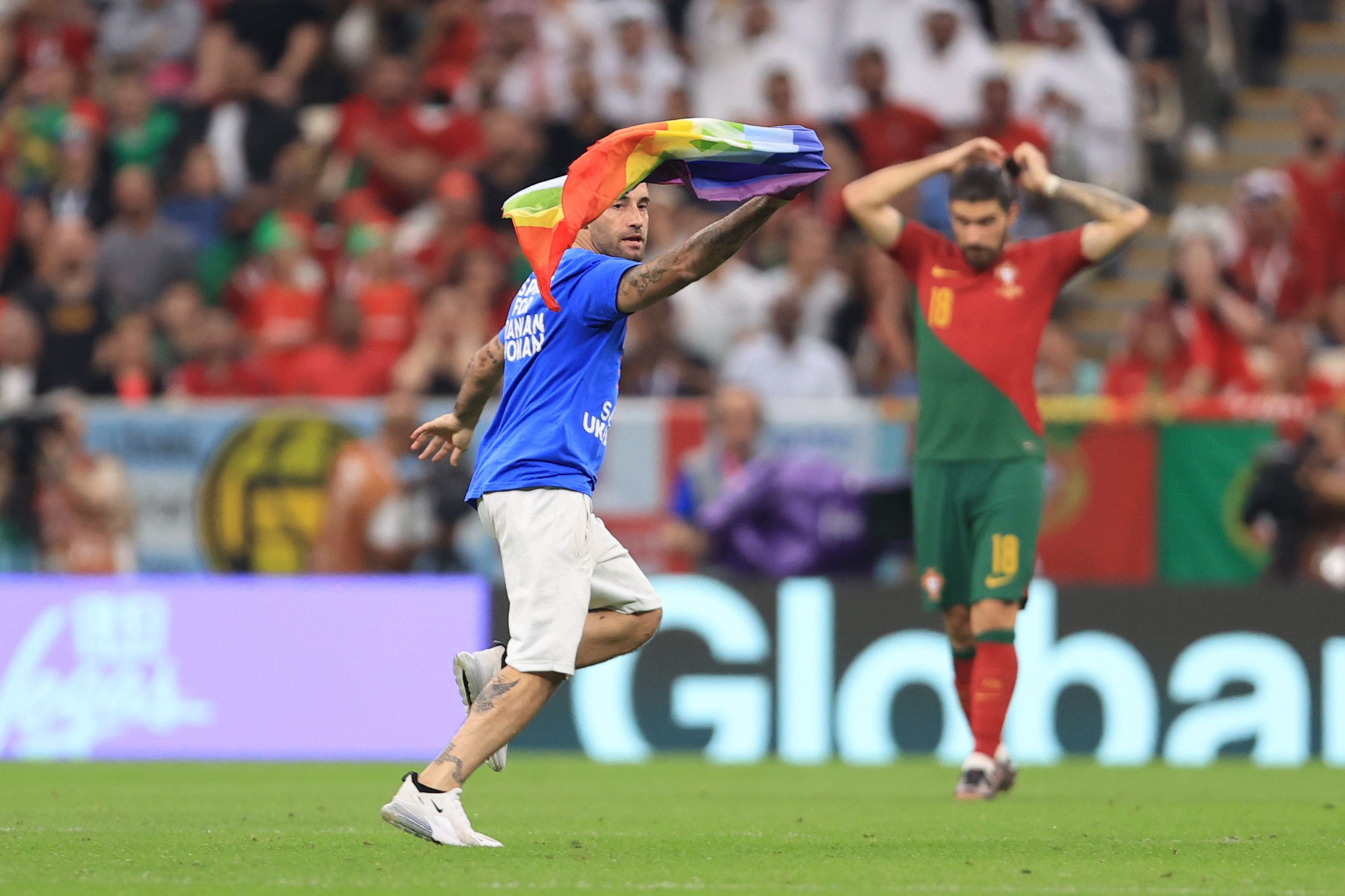 Torcedor com uma bandeira do orgulho LGBTQIA+ e vestindo uma camiseta em solidariedade à Ucrânia e às mulheres iranianas invade o jogo entre Portugal e Uruguai pela Copa do Mundo no Catar