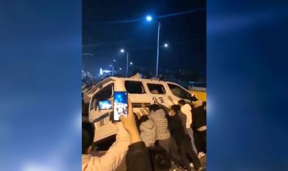 Trabalhadores são vistos derrubando um veículo da polícia durante protesto que se tornou violento na instalação da Foxconn em Zhengzhou, China, em 23 de novembro