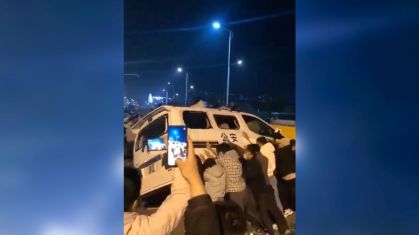 Trabalhadores são vistos derrubando um veículo da polícia durante protesto que se tornou violento na instalação da Foxconn em Zhengzhou, China, em 23 de novembro