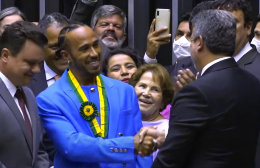 Lewis Hamilton cumprimenta Arthur Lira pelo recebimento da medalha honorífica. Reprodução/ TV Câmara