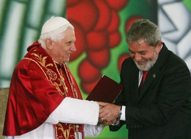 O então papa Bento XVI e o então presidente Luiz Inácio Lula da Silva se cumprimentam no Palácio dos Bandeirantes na cerimônia do lançamento do selo comemorativo da visita do ecumênico ao Brasil, em 10 de maio de 2007.