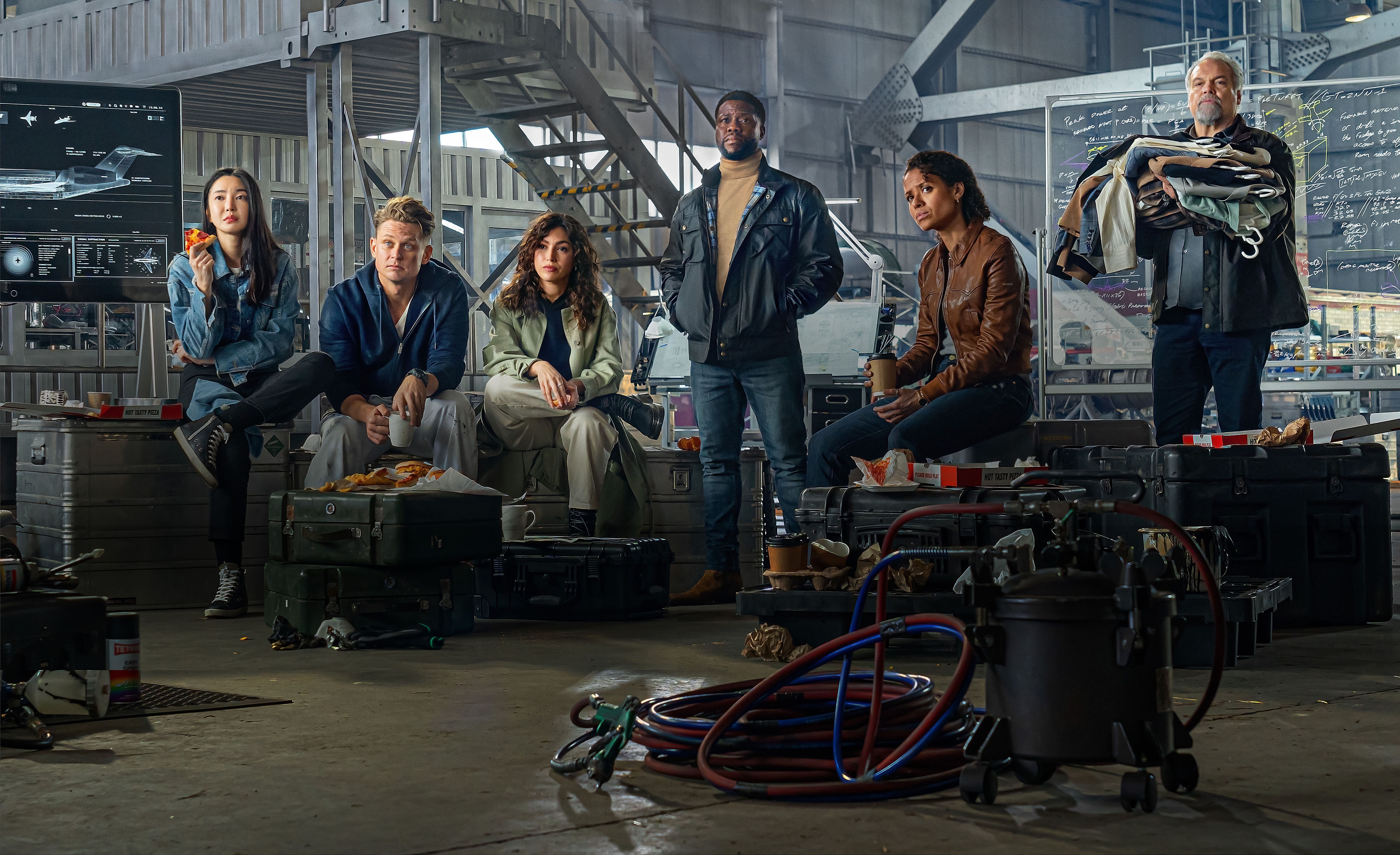YunJee Kim as Mi-Su, Billy Magnussen como Magnus, Úrsula Corberó como Camila, Kevin Hart como Cyrus, Gugu Mbatha-Raw como Abby e Vincent D’Onofrio como Denton em Lift. / Christopher Barr/Netflix