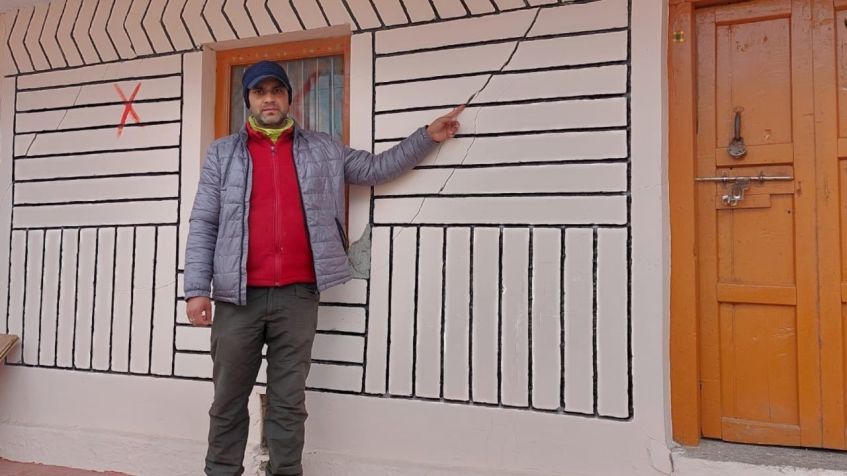 Suraj Kaparuwan aponta para uma rachadura em sua casa, que está marcada com um X porque é considerada muito perigosa para ocupar/ Foto de Suraj Kaparuwan