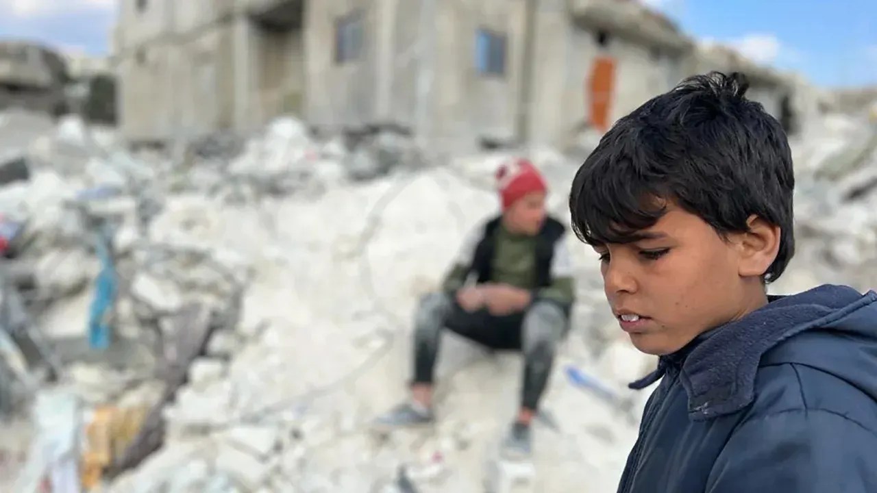 Uma criança está nos escombros que resta de sua antiga casa; Vinte e um membros de sua família morreram no terremoto na Síria / Pete Langley / CNN