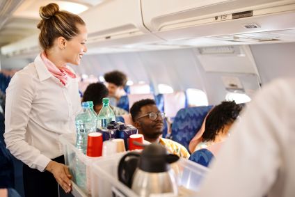 Aeromoças servindo comida e bebidas ao cliente no avião durante o voo