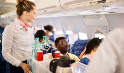 Aeromoças servindo comida e bebidas ao cliente no avião durante o voo
