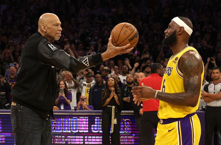 Kareem Abdul-Jabbar cerimoniosamente entrega a bola a LeBron James nº 6 do Los Angeles Lakers depois que James ultrapassou Abdul-Jabbar e se tornou o maior artilheiro de todos os tempos da NBA / Harry How/Getty Images
