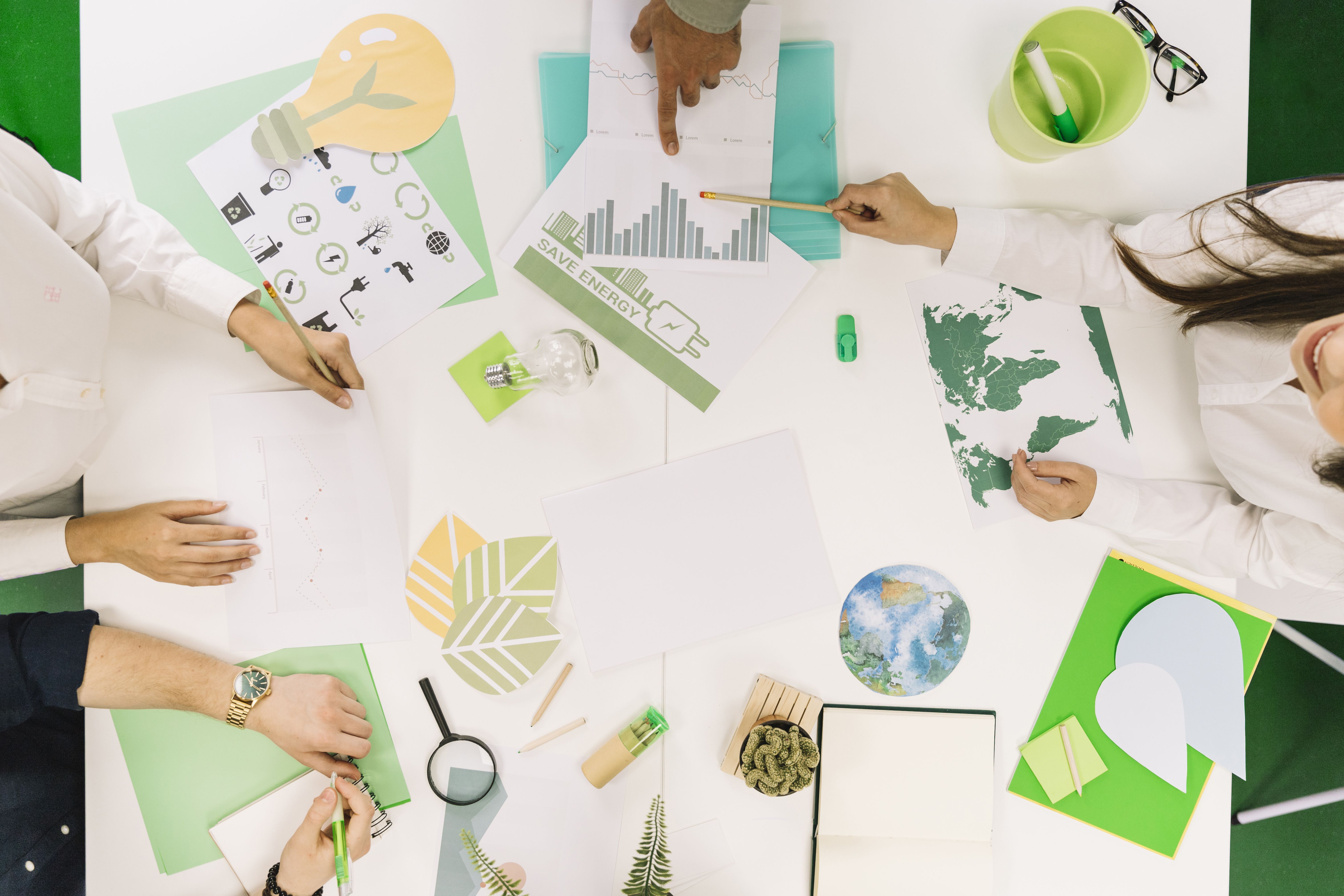 empresarios-que-trabalham-no-grafico-com-varios-recursos-naturais-icone-na-mesa
