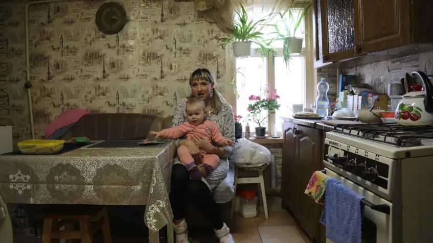 Tetiana Pavelko sentada à mesa da cozinha com Kira no colo / Ghazi Balkiz/CNN