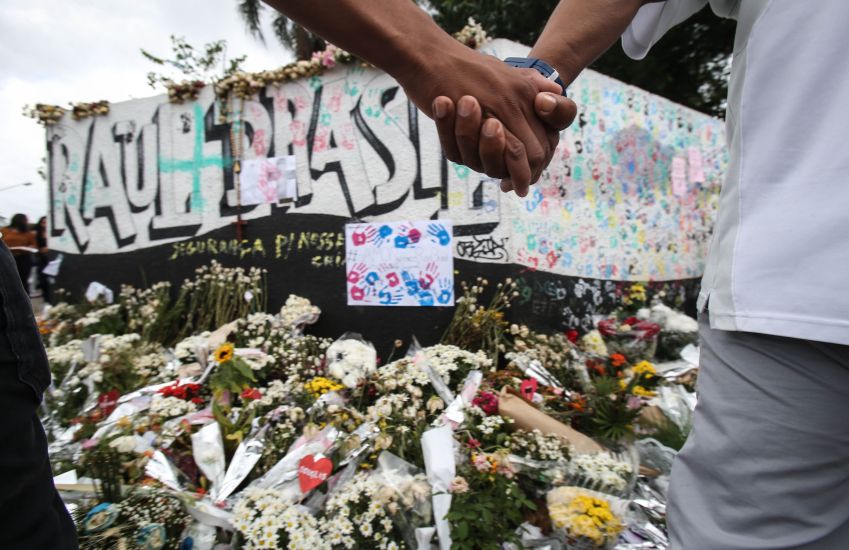 Após ato ecumênico na quadra em homenagem às vítimas do massacre de Suzano, parentes, amigos e alunos realizaram um abraço coletivo no entorno da Escola Estadual Raul Brazil, em Suzano / WERTHER SANTANA/ESTADÃO CONTEÚDO/AE