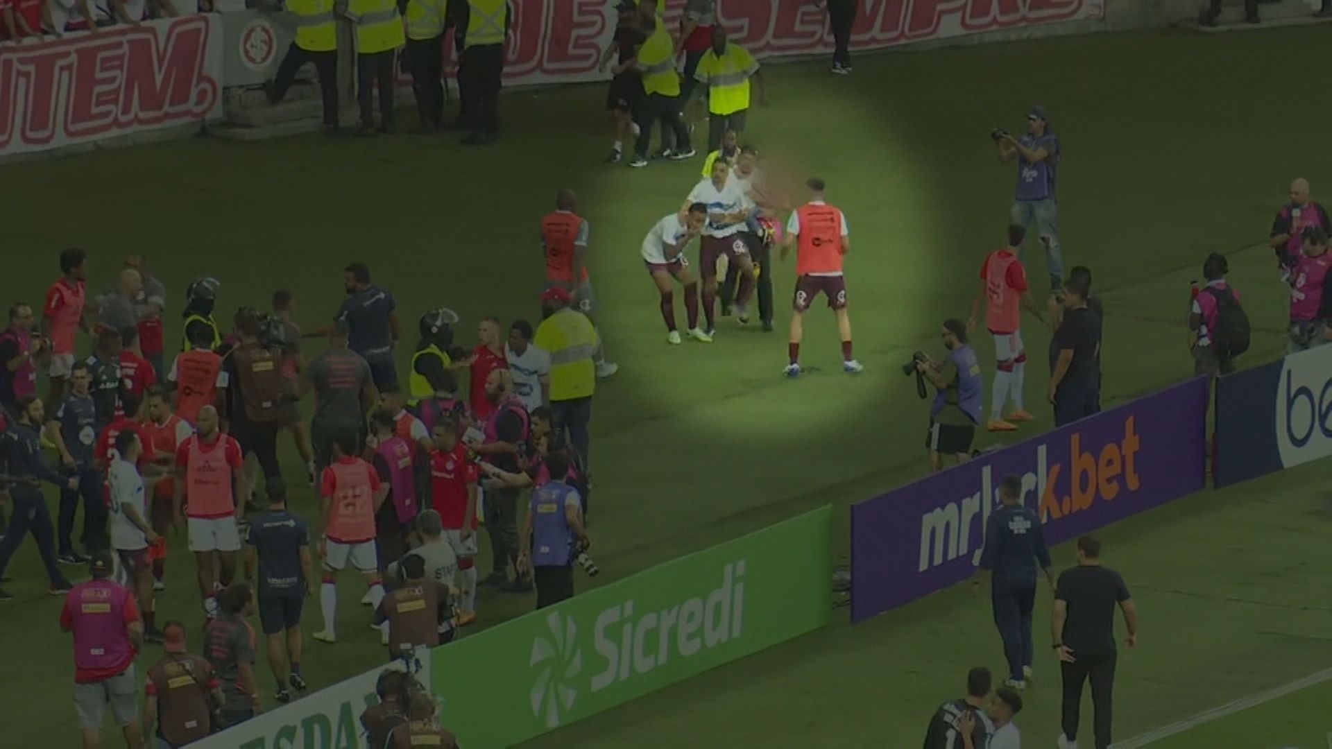 Homem invade campo durante jogo do Internacional com criança de colo.