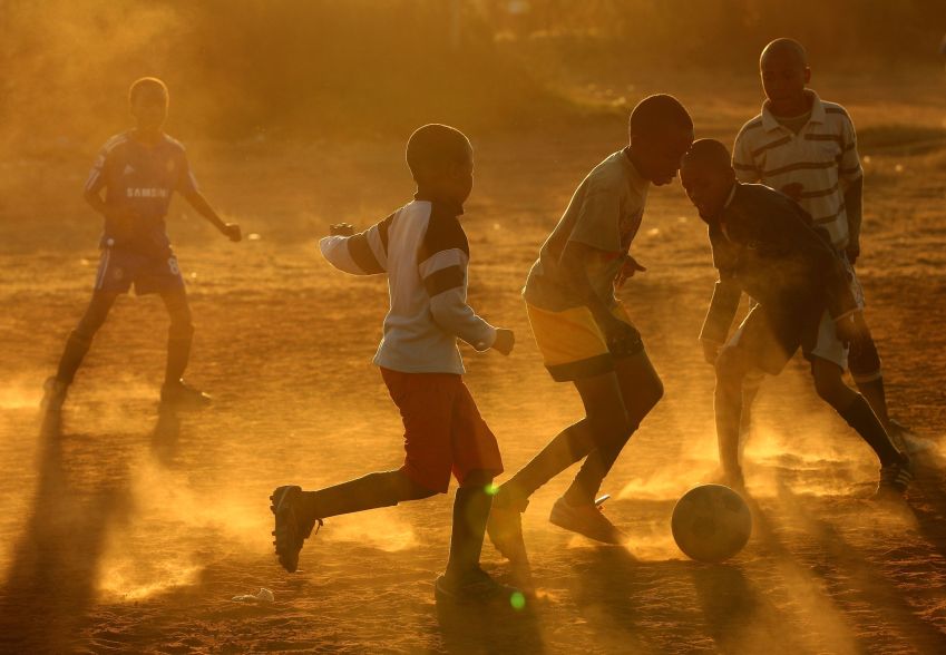 Crianças jogam futebol no Soweto, em Joanesburgo / Getty Images
