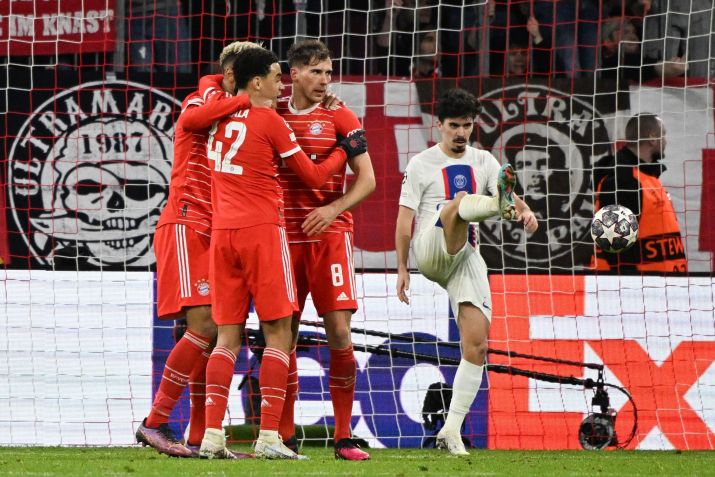 Enquanto os jogadores do Bayern comemoram o 1 a 0, o jogador do PSG, Vitinha, chuta para o meio./ Peter Kneffel/ Getty Images