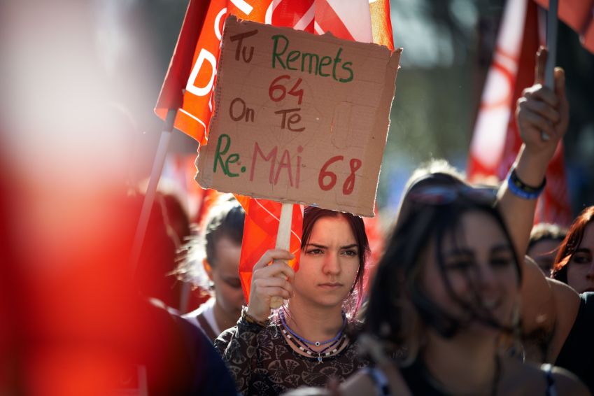 Um estudante segura um cartaz em protestos contra propostas de Emmanuel Macron de fazer os franceses trabalharem mais antes aposentadoria / Alain Pitton/NurPhoto via Getty Images