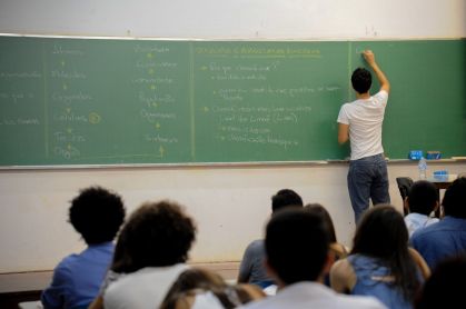 Professor de cursinho escrevendo na lousa