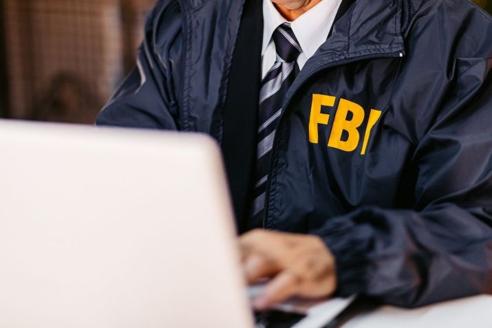 Detetive do FBI usando laptop em seu escritório • Getty Images