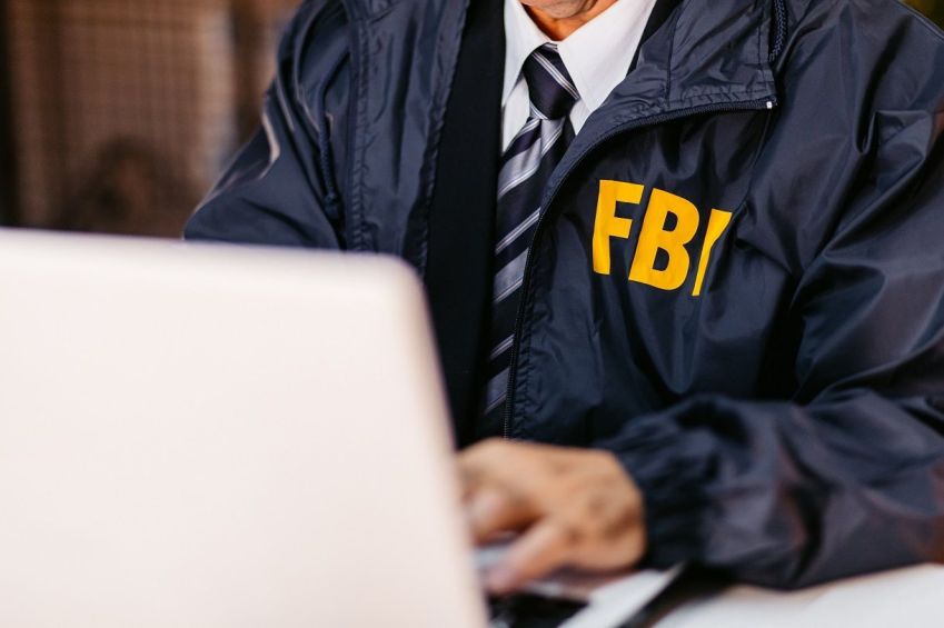 Detetive do FBI usando laptop em seu escritório • Getty Images