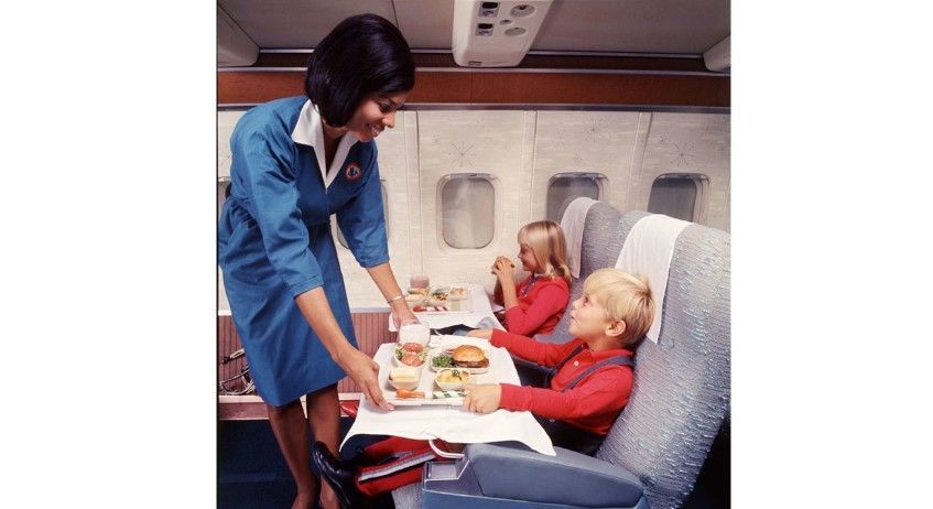 Jovem comissária de bordo serve crianças em voo da American Airlines / American Airlines/Arquivo
