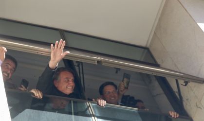 O ex-presidente Jair Bolsonaro acena de uma janela na sede do PL, em imagem de 30 de março de 2023