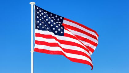American flag waving in blue sky