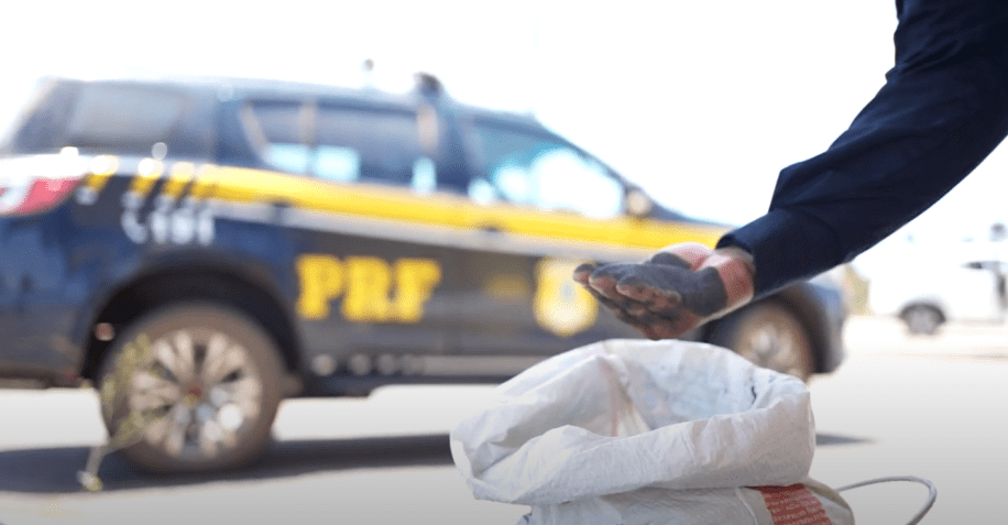 Policial manuseando cassiterita que foi apreendida / Divulgação/PRF