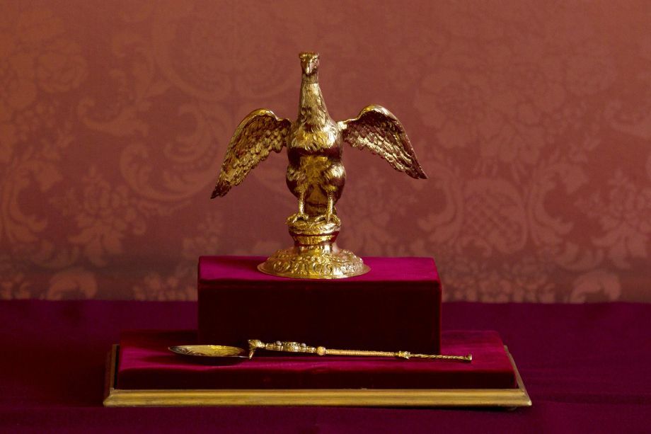 A ampola, feita de ouro fundido em forma de uma águia com as asas abertas, guarda o óleo sagrado usado para ungir o rei e a rainha consorte. Abaixo, a colher da coroação, usada no momento da unção, é o objeto mais antigo usado nas coroações, única peça que sobreviveu do século 12. / Divulgação/ Palácio de Buckingham