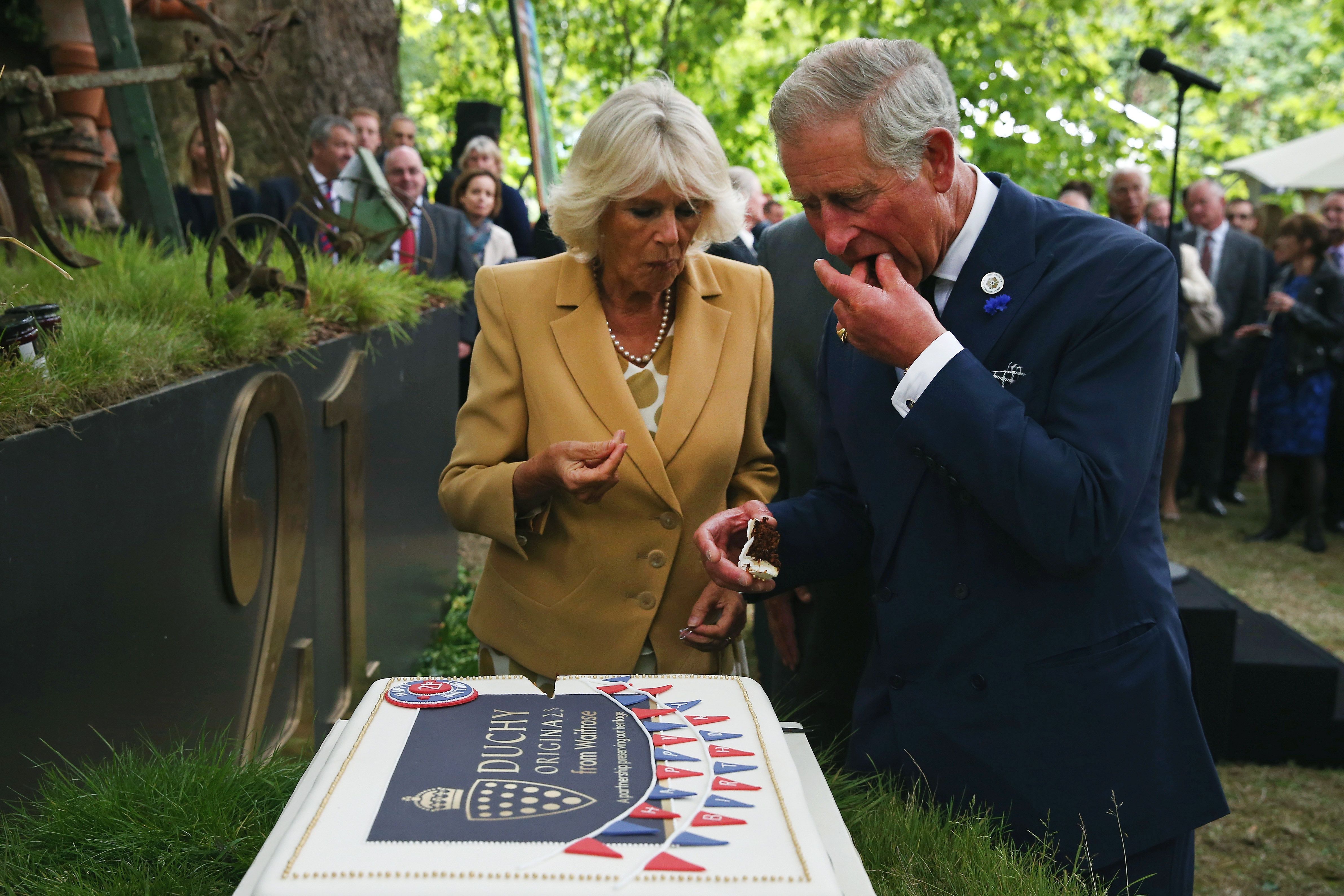LONDRES, INGLATERRA - 11 DE SETEMBRO: Príncipe Charles, Príncipe de Gales e Camilla, Duquesa da Cornualha cortaram um bolo para comemorar o 21º aniversário dos produtos originais do Ducado na Clarence House em 11 de setembro de 2013 em Londres, Inglaterra. A recepção foi realizada nos jardins da Clarence House, e contou com a presença de fornecedores da Duchy, Waitrose e outros armazenistas internacionais, clientes, beneficiários de caridade e representantes de algumas das instituições de caridade que se beneficiam da venda dos produtos.