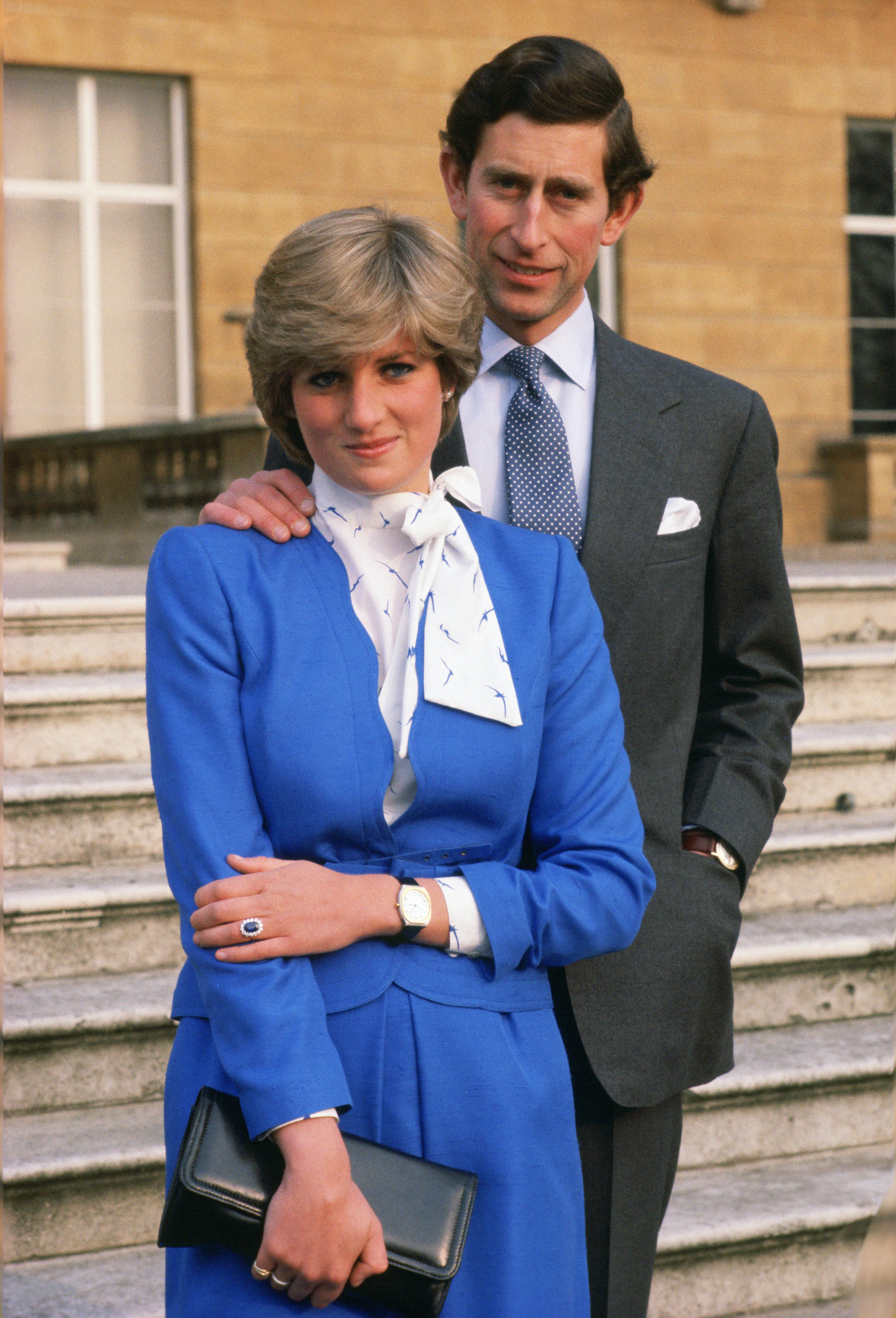 Lady Diana Spencer (mais tarde princesa de Gales) revela seu anel de noivado de safira e diamante enquanto ela e o então príncipe Charles posam para fotos no terreno do Palácio de Buckingham após o anúncio do noivado.  Tim Graham Photo Library/Getty Images