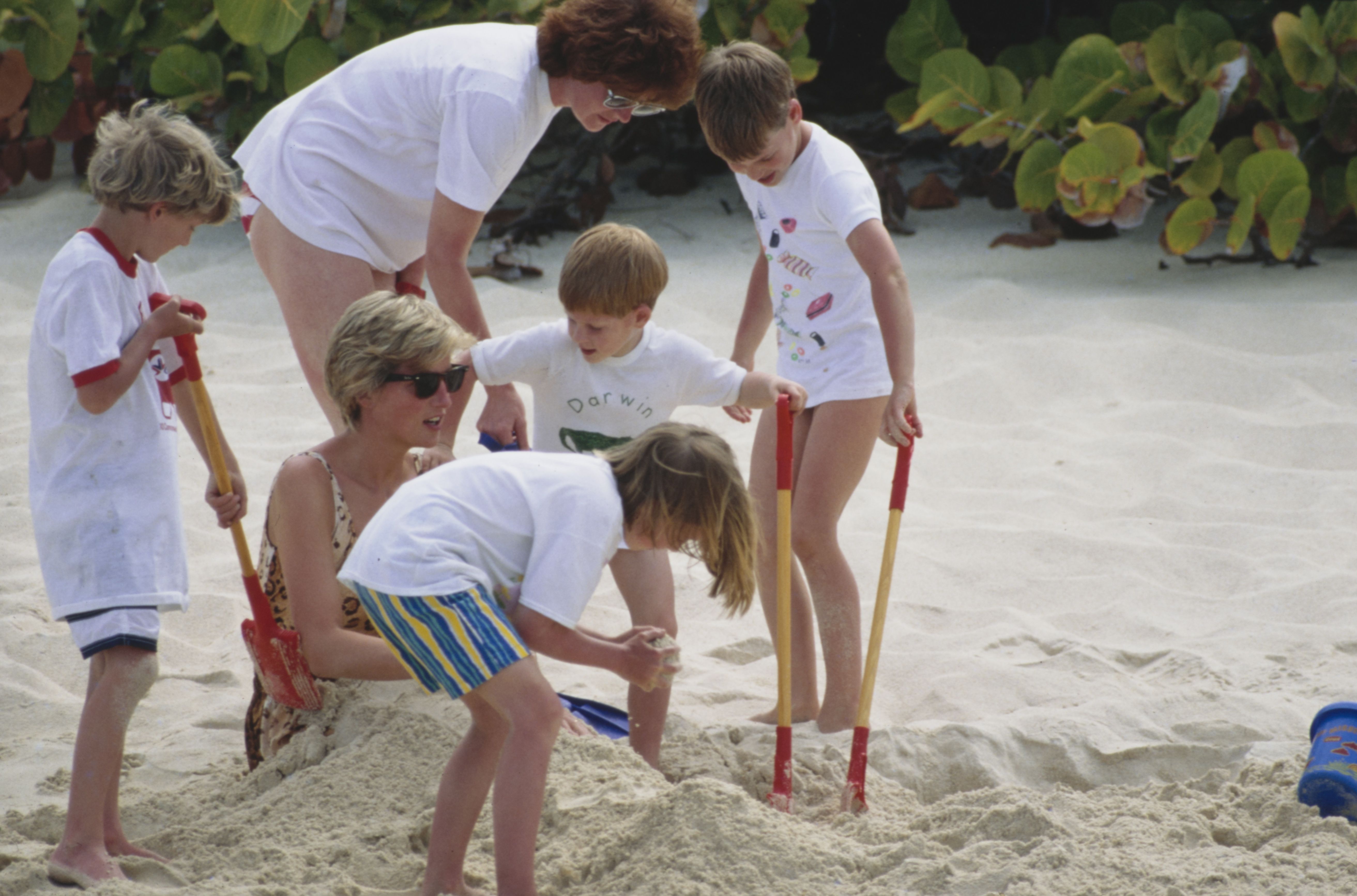 Princesa Diana vestindo um maiô durante férias com seus filhos, príncipe William e príncipe Harry, e sua irmã, Sarah McCorquodale, e os filhos da irmã, Emily McCorquodale e George McCorquodale, em abril de 1990. Tim Graham Photo Library/Getty Images