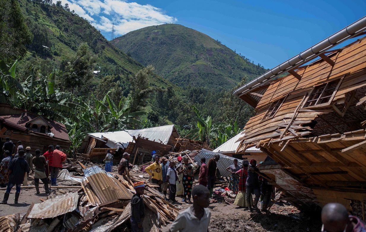 Cidadãos congoleses resgatam pertences em meio a destroços após enchentes, em Nyamukubi, República Democrática do Congo