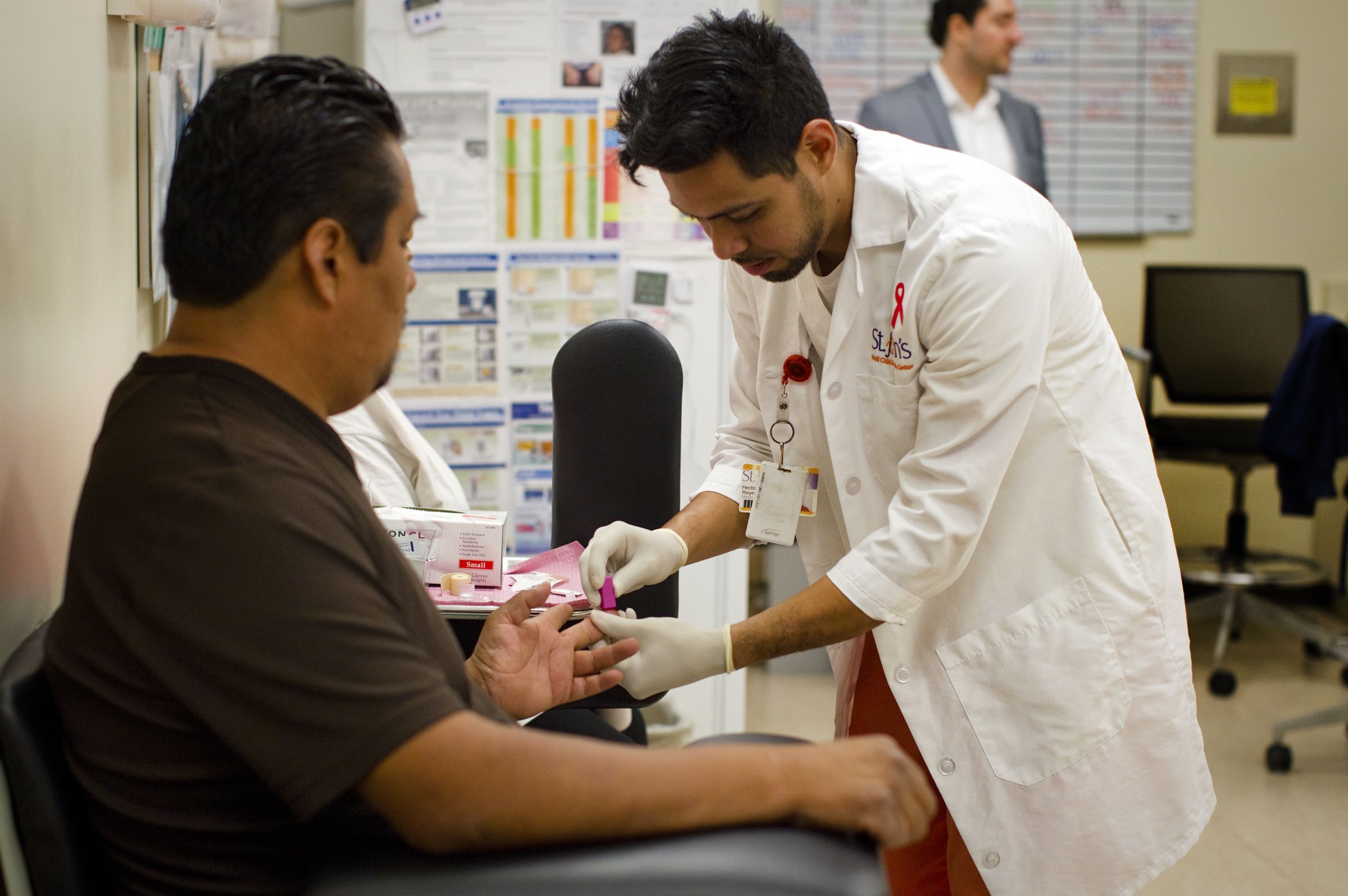 LOS ANGELES, CA -18 DE MARÇO DE 2014: O assistente médico Hector Reyes administra um teste de sangue para HIV ao paciente Jose De La Cruz, 42, de Los Angeles no St. John's Well Child and Family Center em 18 de março de 2014 em Los Angeles, Califórnia . A clínica administra testes de HIV a todos os seus pacientes, mas em menos de duas semanas o financiamento para o teste pode ser cortado devido a uma mudança nas diretrizes federais. (Foto de Gina Ferazzi/Los Angeles Times via Getty Images)