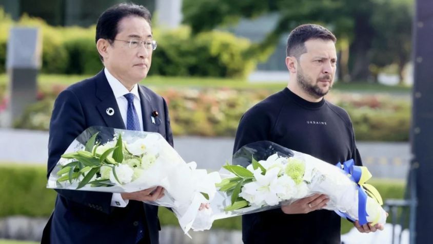 O primeiro-ministro japonês Fumio Kishida e o presidente ucraniano Volodymyr Zelensky caminham em direção ao cenotáfio para as vítimas da bomba atômica no Parque Memorial da Paz em Hiroshima em 21 de maio de 2023. / Kyodo News/Getty Images