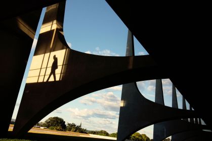 Vista dos arcos do Palácio do Planalto, sede do poder Executivo, com detalhe da sombra de um homem em uma das pilastras