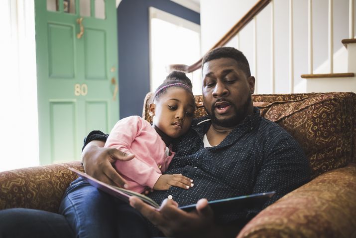 Pai e filha lendo um livro. / Getty Images