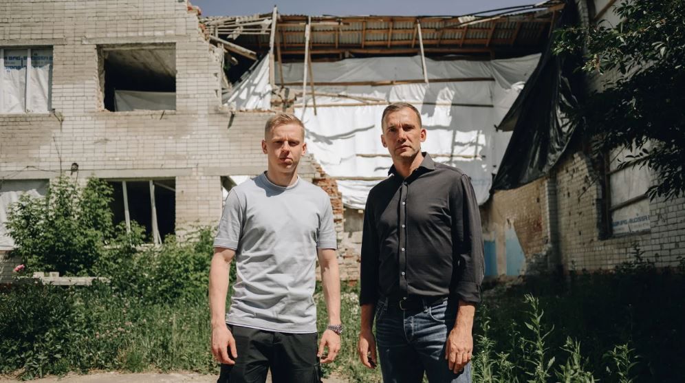 Oleksandr Zinchenko e Andriy Shevchenko visitam uma escola no norte da Ucrânia que foi danificada por um míssil russo. / Cortesia United 24