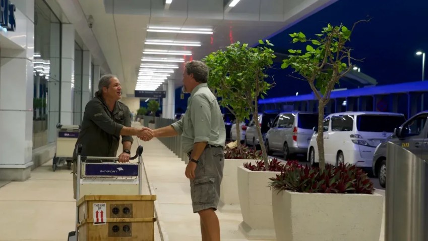 Gerardo Garcia (à esquerda) cumprimenta o ecologista da vida selvagem Mark Outerbridge ao chegar às Bermudas com a caixa de caracóis ameaçados de extinção / Sandy Thin/CNN