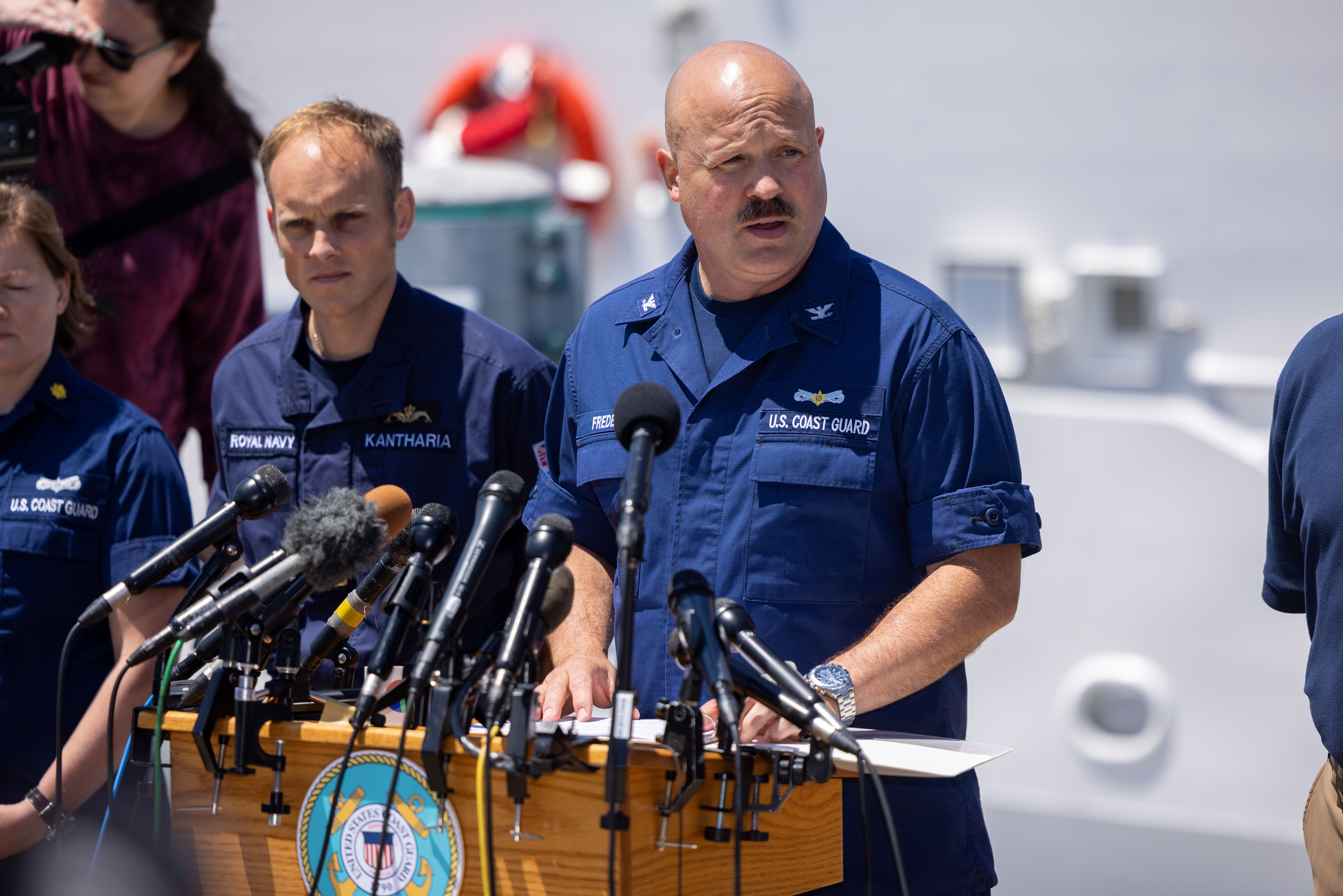 BOSTON, MASSACHUSETTS - 21 DE JUNHO: O Capitão Jamie Frederick da Guarda Costeira dos EUA, acompanhado por outros da Marinha dos EUA, Marinha Real e Woods Hole Oceanographic Institute, atualiza os esforços de busca de cinco pessoas a bordo de um submersível desaparecido a aproximadamente 900 milhas ao largo de Cape Cod, em 21 de junho de 2023 em Boston, Massachusetts. A Guarda Costeira está correndo para encontrar um submersível com cinco passageiros que desapareceram durante um mergulho nos destroços do Titanic. (Foto de Scott Eisen/Getty Images)
