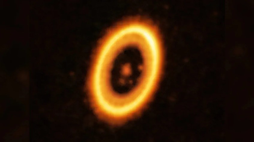 Esta imagem, tirada com o Atacama Large Millimeter/submillimeter Array, mostra o sistema planetário PDS 70. No centro está uma estrela, que é orbitada por dois planetas. A estrutura em forma de anel é um disco circunstelar de material, que dá origem aos planetas. / ALMA (ESO/NAOJ/NRAO)/Balsalobre-Ruza