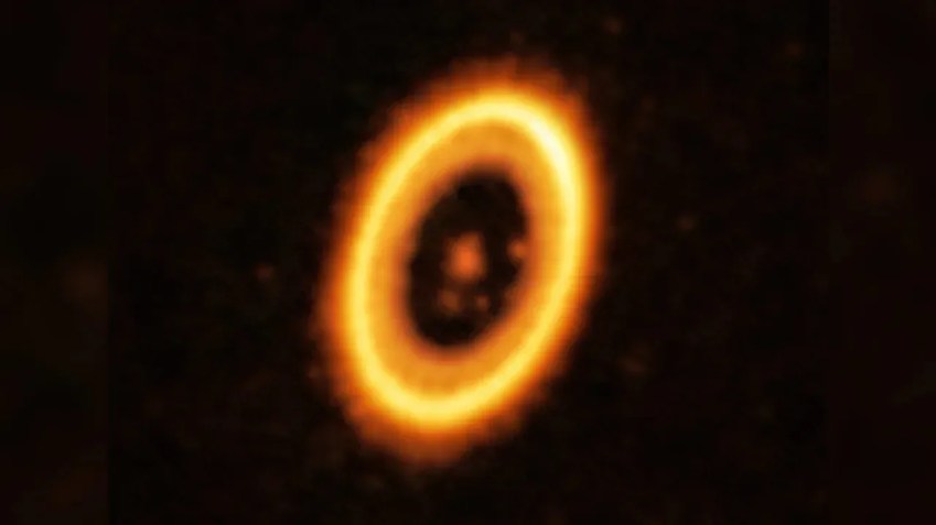 Esta imagem, tirada com o Atacama Large Millimeter/submillimeter Array, mostra o sistema planetário PDS 70. No centro está uma estrela, que é orbitada por dois planetas. A estrutura em forma de anel é um disco circunstelar de material, que dá origem aos planetas. / ALMA (ESO/NAOJ/NRAO)/Balsalobre-Ruza