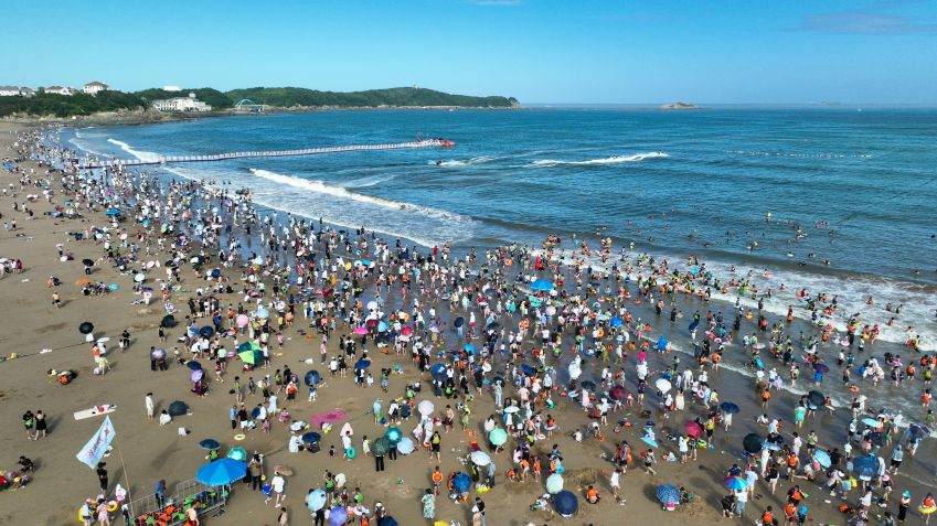 Turistas fogem do calor do verão na área de Nansha Scenic de Zhujiajian na cidade de Zhoushan, província de Zhejiang, na China. / Future Publishing/Getty Images