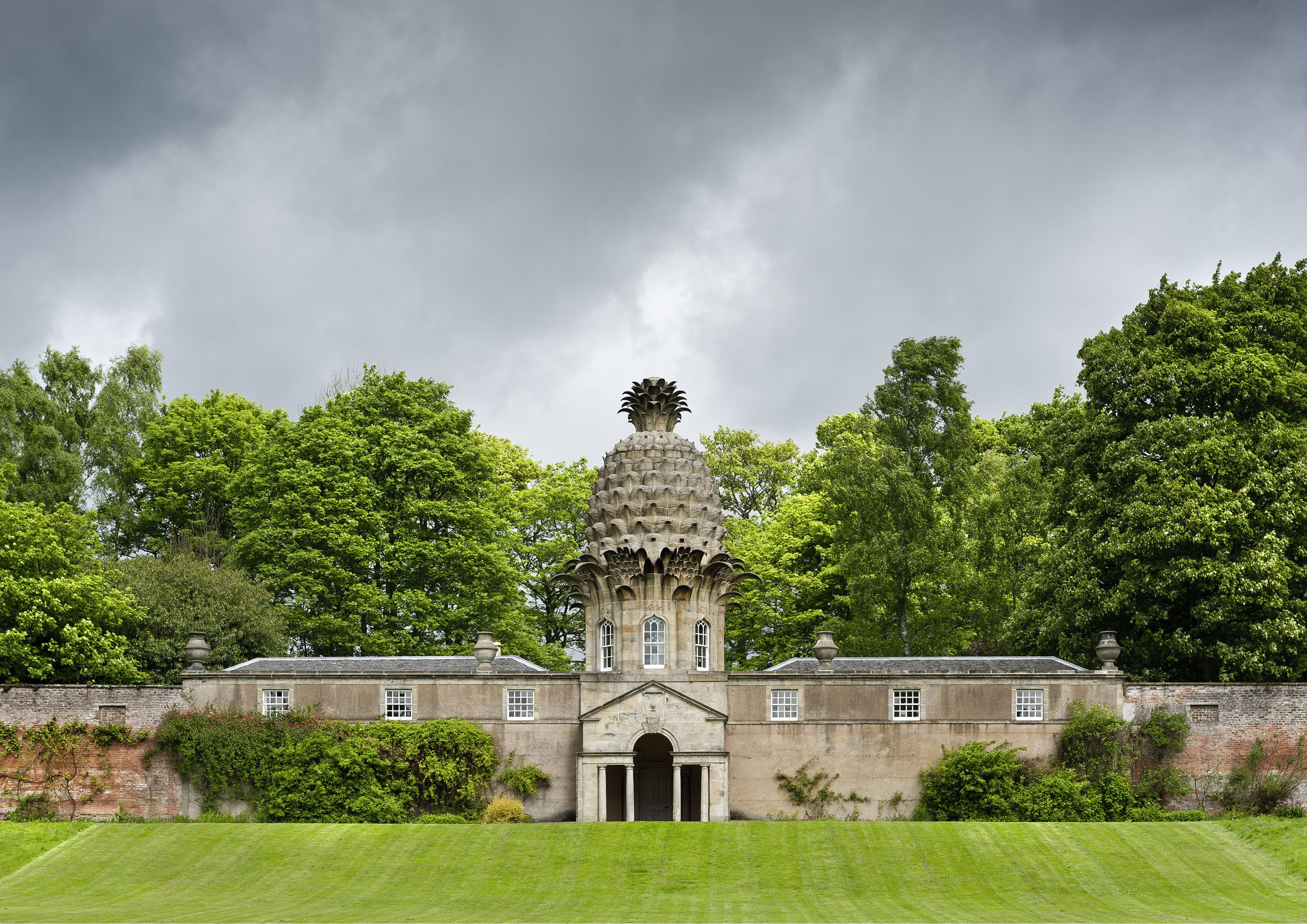 Os designs de abacaxi ainda sobrevivem em alguns edifícios notáveis ​​em toda a Grã-Bretanha associados à realeza, incluindo The Pineapple House em Dunmore Park, na Escócia / Imagno/Getty Images