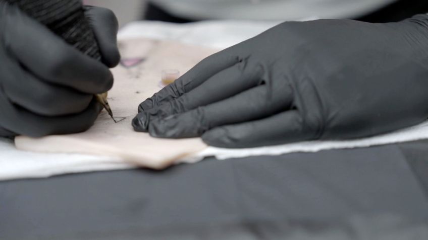 Um tatuador em Londres pratica com tinta inteligente desenvolvida pelo pesquisador Ali Yetisen em um pedaço de pele de porco. / CNN