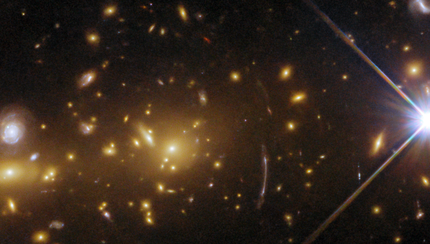 Detalhe da imagem mostra galáxias distorcidas pela presença de uma lente gravitacional. / ESA/Hubble & Nasa, H. Ebeling